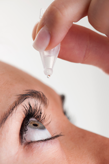Photo of woman applying eye drops