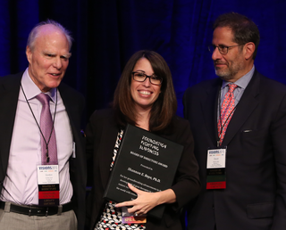 Phot of Dr. Shannon Boye holding her Foundation Board of Director's Award, flanked by Foundation co-founder and Chairman Emeritus Gordon Gund and Chairman David Brint