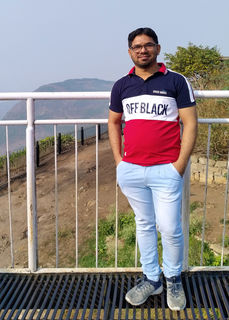 Sohel Pathan standing in front of a white railing with hills and mountains in the background.